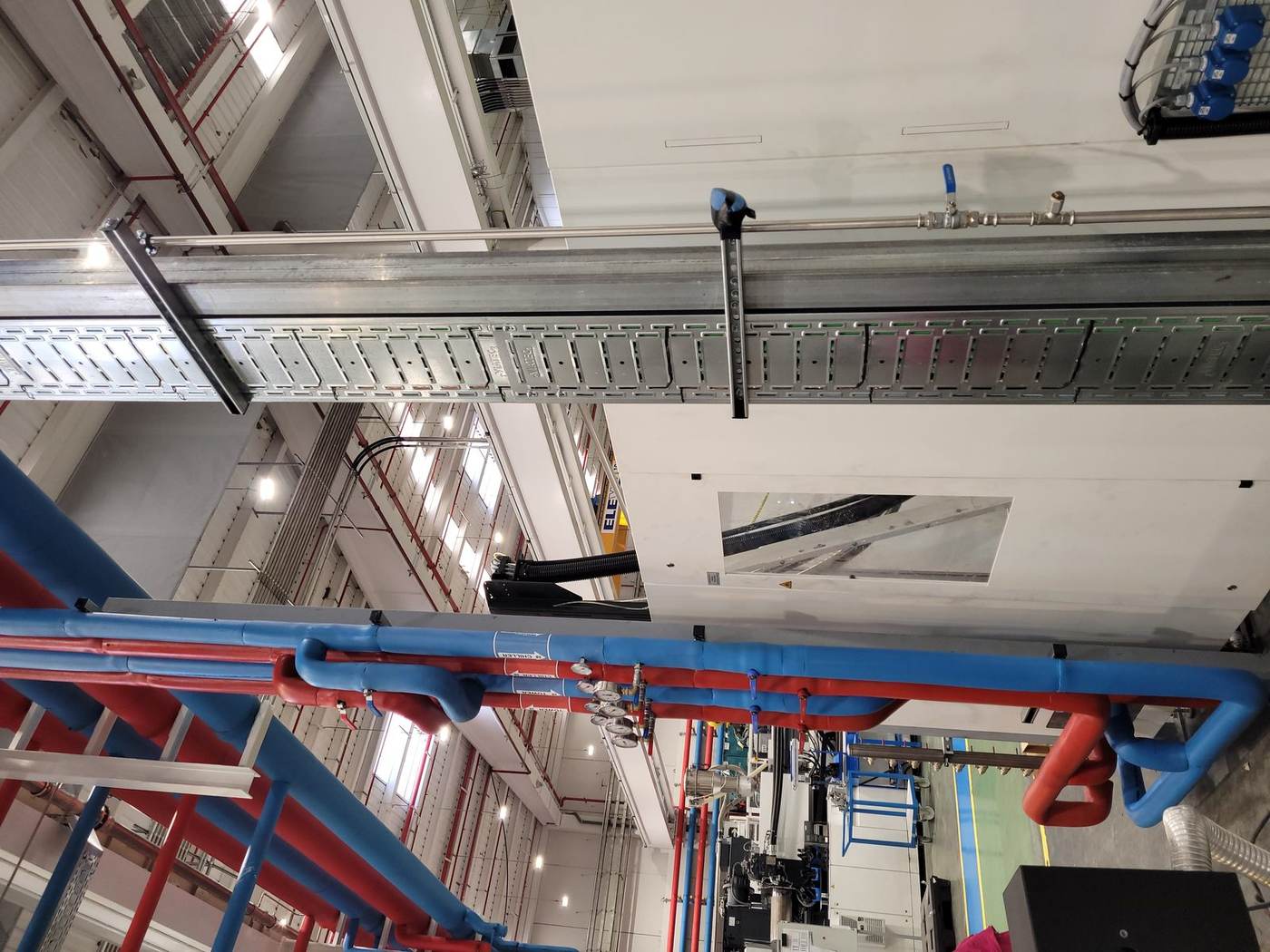 Bandejas de cables y canalizaciones bajo el techo de una nave industrial