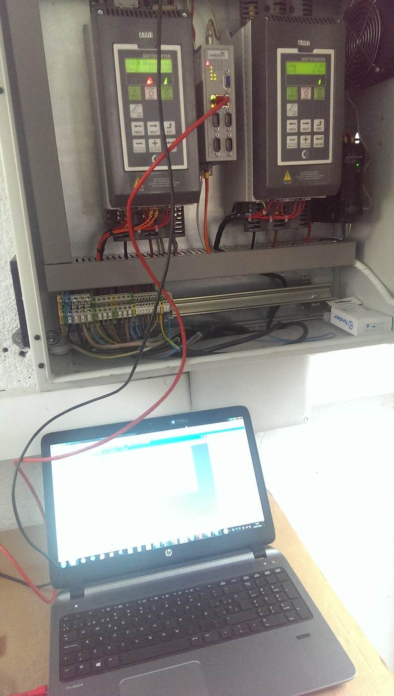 Técnico midiendo con un portátil conectado a un cuadro eléctrico