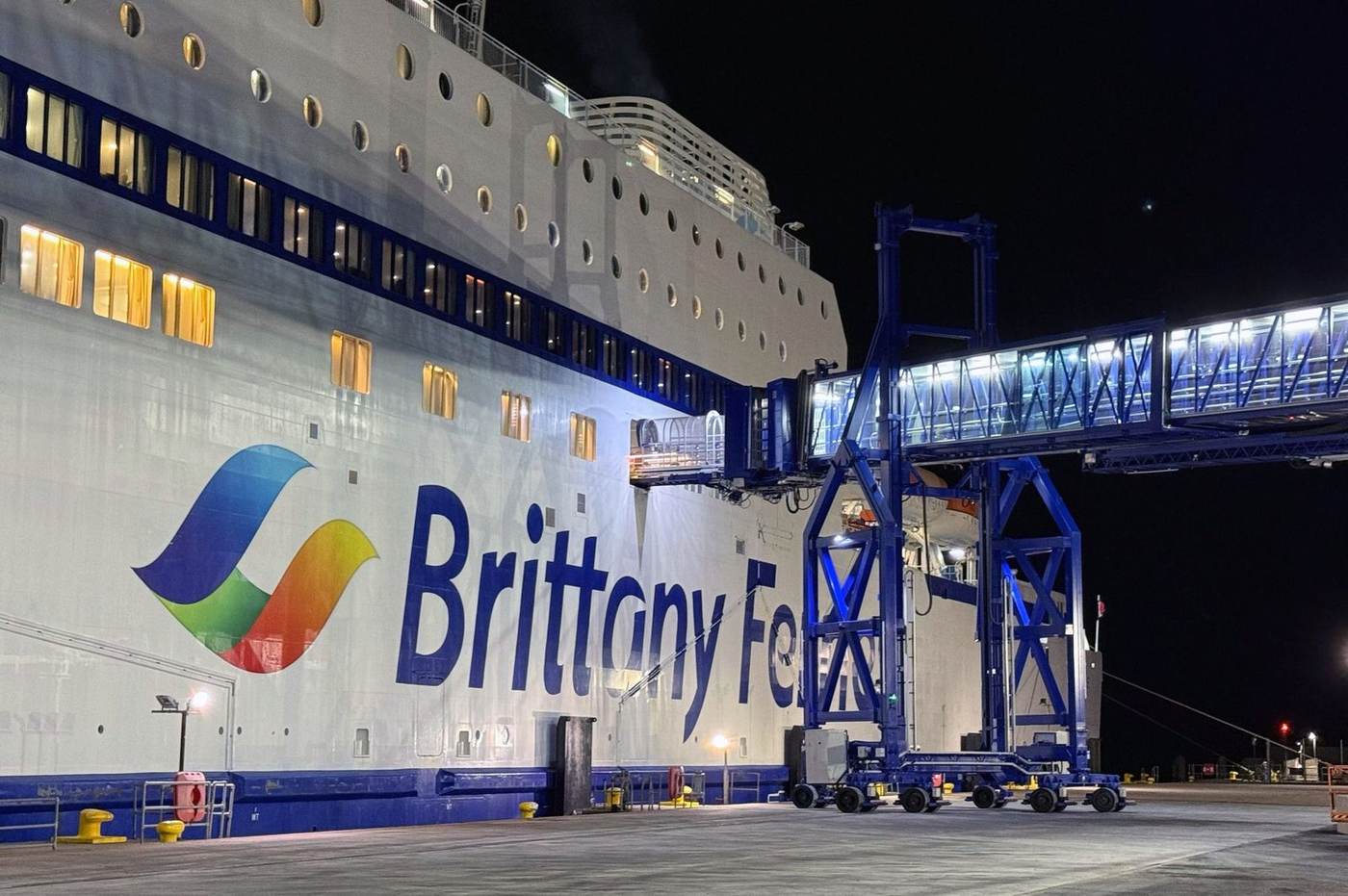 Pasarela de puerto de noche con un ferry atracado en Plymouth