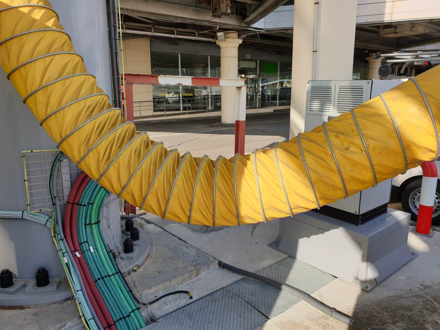 Conducto de aire preacondicionado y cableado bajo una pasarela en el aeropuerto de Sevilla